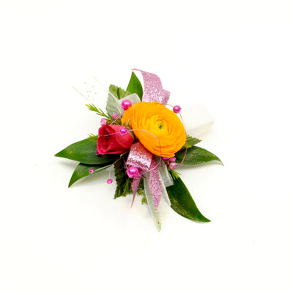 Yellow ranunculus and a red rose with white flowers, green leaves, pink ribbon, and pink accents in a wrist corsage.